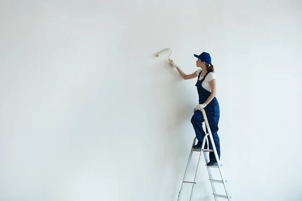 Hus målare måla väggen med roller — Stockfoto