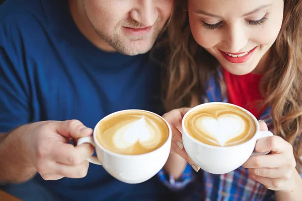 Joven pareja bebiendo capuchino — Foto de Stock