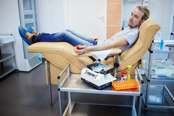 Man sitting in armchair Stock Image