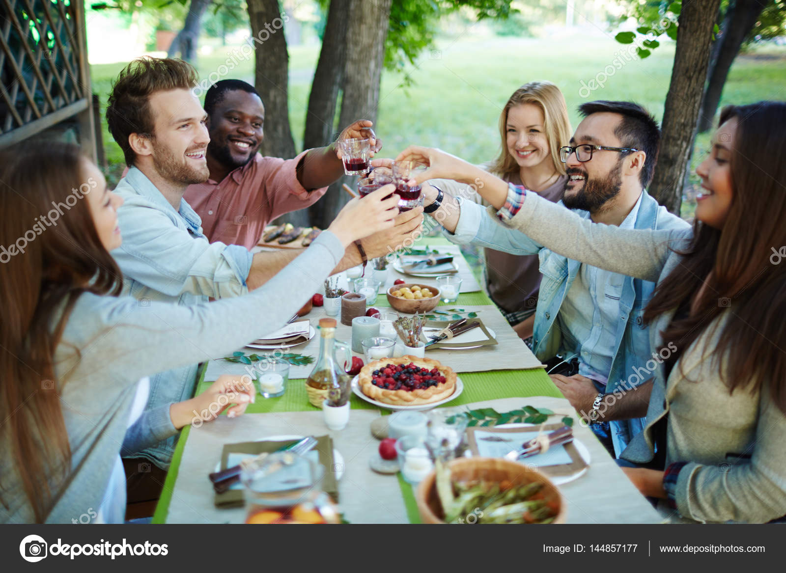 Friends having dinner together Stock Photo by ©pressmaster 144857177