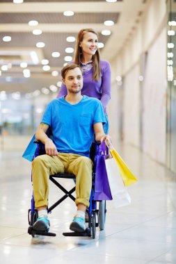 Tekerlekli sandalyede iterek erkek kadın