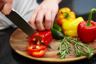 Chef cutting red pepper