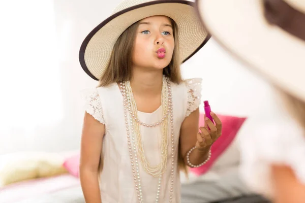 Menina com batom olhando para o espelho — Fotografia de Stock