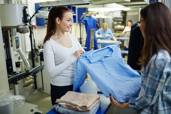 Помощник продавца показывает блузку — стоковое фото
