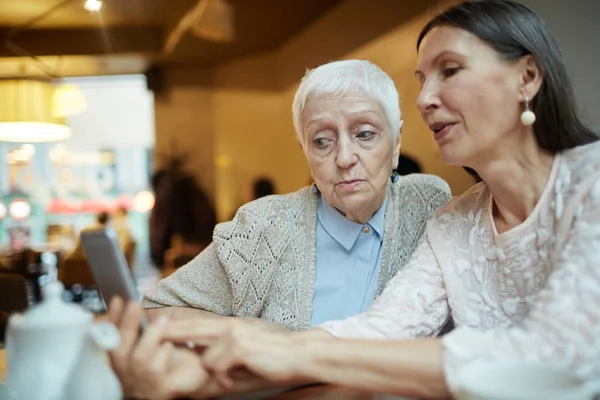 Mujeres maduras navegando en smartphone — Foto de Stock