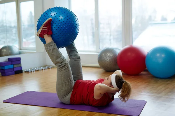 Kvinna som utför raka ben sit ups — Stockfoto