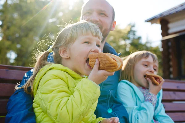 Little girls eating delicious hot dog — Stock Photo, Image