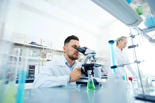 Trabajador de laboratorio sentado junto a la mesa — Foto de Stock