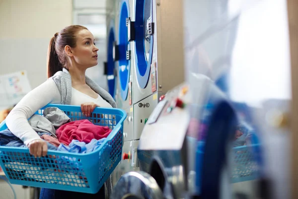 Frau mit Wäschekorb in der Wäscherei — Stockfoto