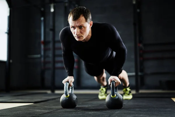 Adam kettlebell şınav gerçekleştirme — Stok fotoğraf