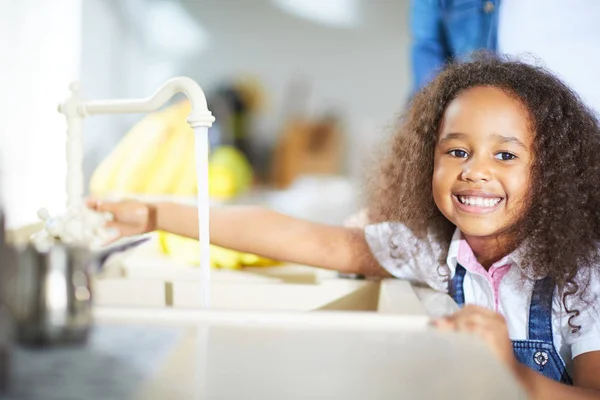 Girl turning on tap — Stock Photo, Image