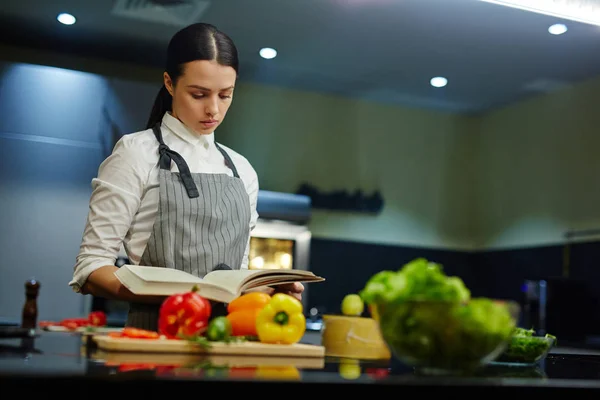 Vrouw met kookboek — Stockfoto