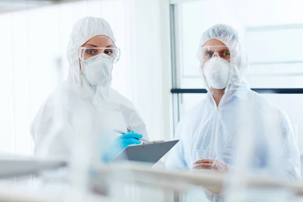 Colleagues in eyeglasses, gloves and respirators — Stock Photo, Image