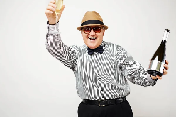 Pensioner raising a glass of champagne — Stock Photo, Image