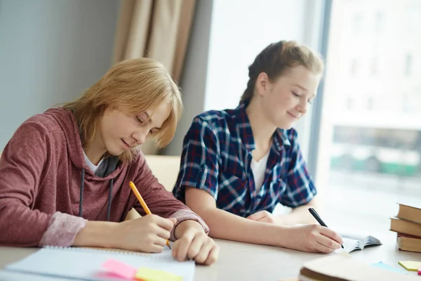 Guy and girl writing essay — Stock Photo, Image