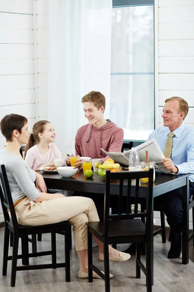 Family talking by kitchen table — Stock Photo, Image