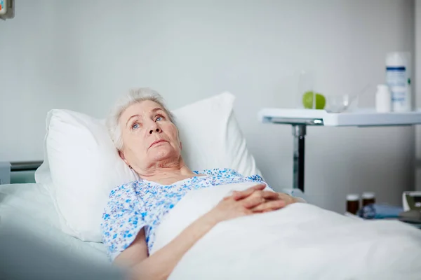 Senior woman lying thoughtful — Stock Photo, Image