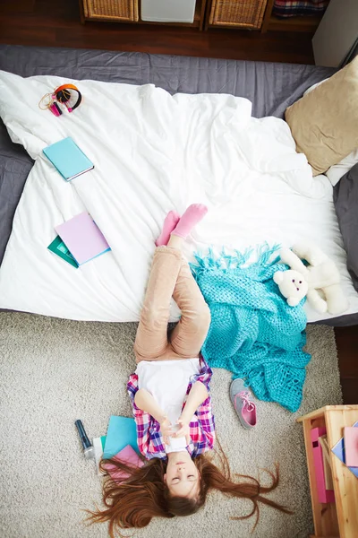 Mädchen liegt mit den Beinen auf dem Bett — Stockfoto