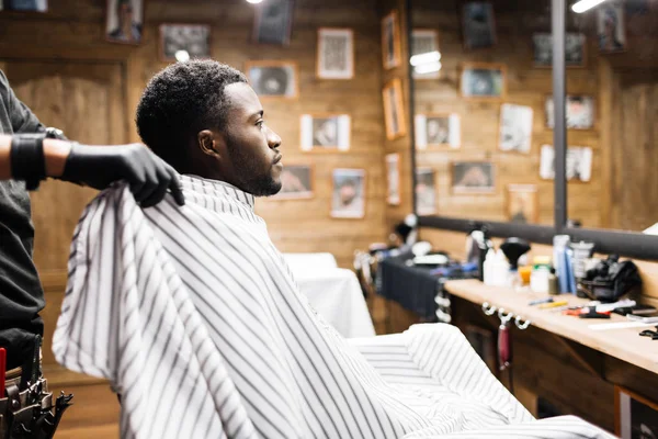 Afrikanska killen sitter i barbershop — Stockfoto