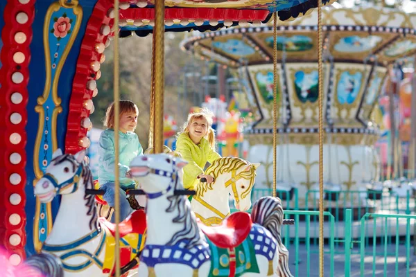 Meisjes rijden op merry-go-round — Stockfoto