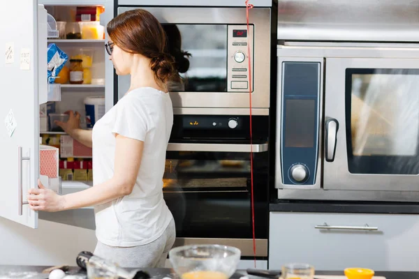 Housewife opening door of fridge — Stock Photo, Image