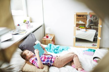 kitap ile oturan kız