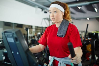 Spor salonunda makineleri kullanan kadın