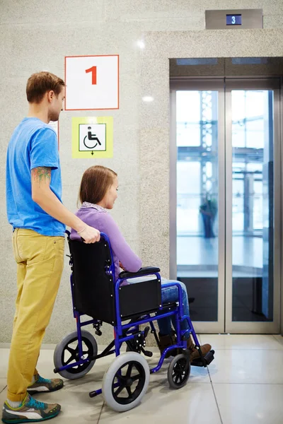 Vrouw in rolstoel en assistent — Stockfoto