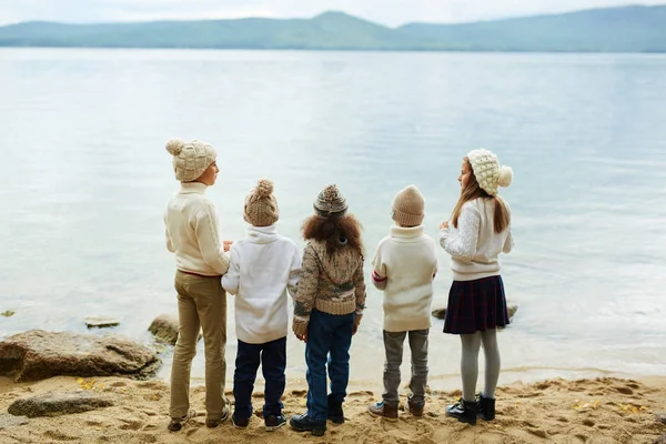 Niños de pie junto al agua — Foto de Stock