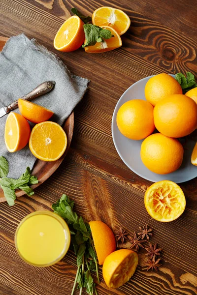 Ripe oranges cut in half, mint, cinnamon — Stock Photo, Image