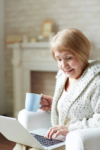 Moderna mormor chattar på laptop — Stockfoto