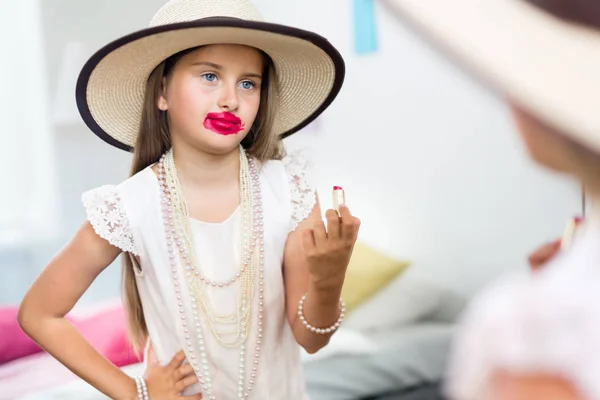 Niña con lápiz labial mirando al espejo — Foto de Stock