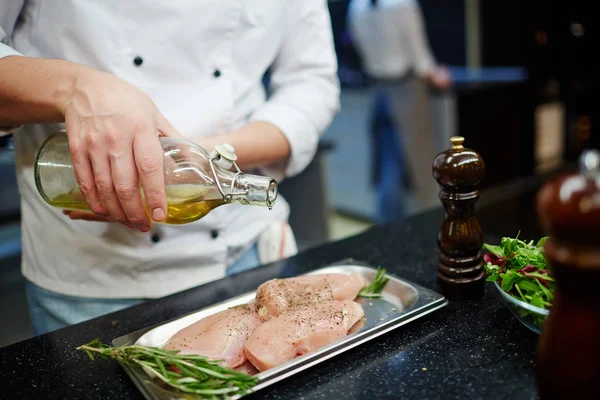 Chef-kok gieten olijfolie — Stockfoto