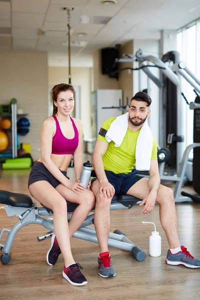 Man and woman sitting on adjustable bench — Stock Photo, Image