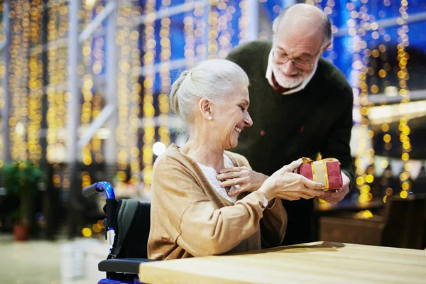 Mujer discapacitada tomando una pequeña caja de regalo — Foto de Stock