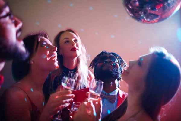 Vrienden met champagne disco bal kijken — Stockfoto