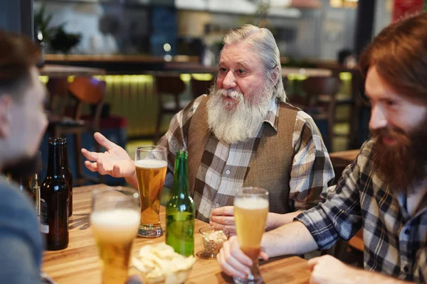 Senior man talking to guys — Stock Photo, Image