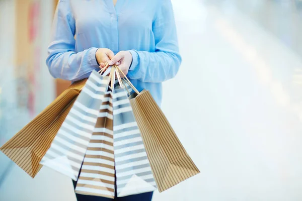 Several paperbags in hands — Stock Photo, Image