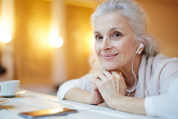 Senior femelle avec écouteurs — Photo