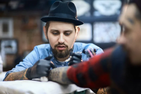 Концентрированный мастер татуировки — стоковое фото