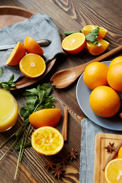Ripe oranges cut in half, mint, cinnamon — Stock Photo, Image