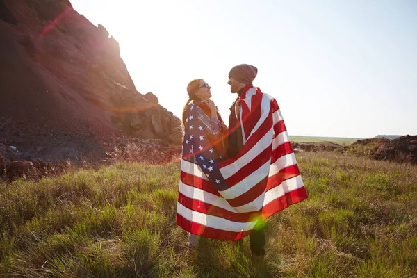 Casal envolto em bandeira americana — Fotografia de Stock