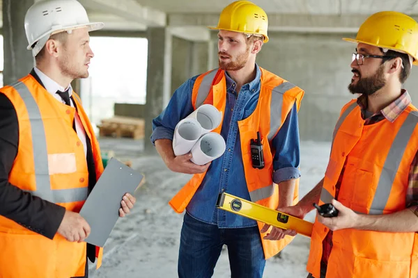 Robotników trzyma narzędzia i plany — Zdjęcie stockowe