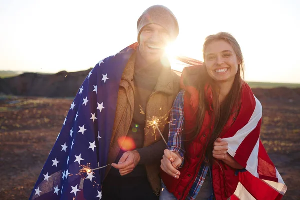 Пара, завернутая в американский флаг — стоковое фото