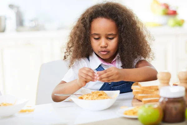 Girl having lunch adding cheese to spaghetti — Stock Photo, Image