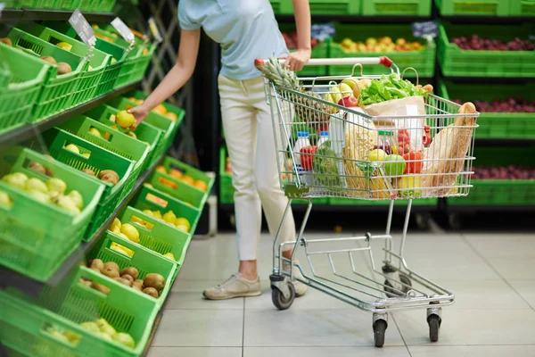 Женщина в овощном отделе супермаркета — стоковое фото