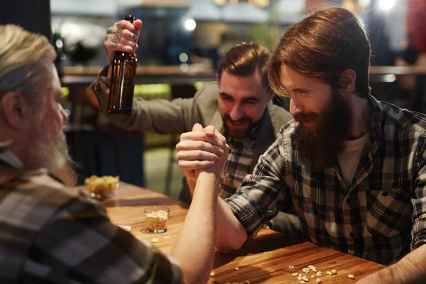 Wrestling competition over table in pub — Stock Photo, Image