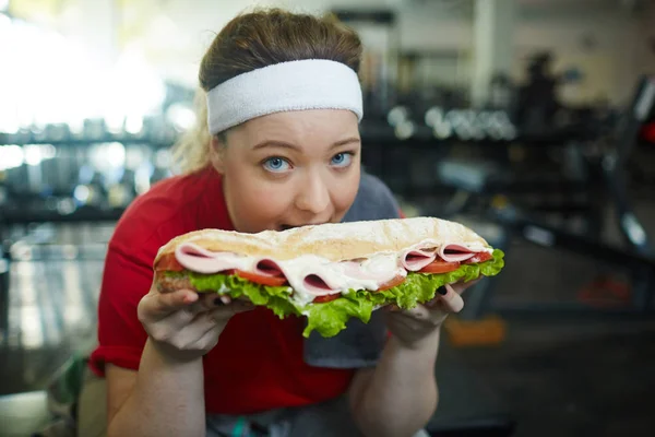 Mulher mordendo em enorme sanduíche — Fotografia de Stock