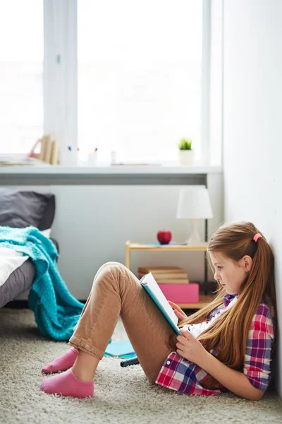 Dziewczyna czytanie książki siedząc — Zdjęcie stockowe