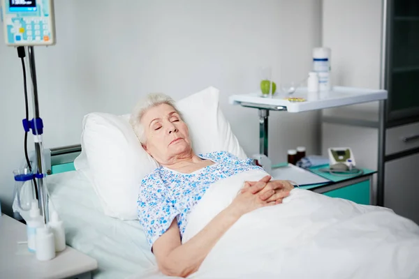 Senior Kvinna sover på sängen — Stockfoto